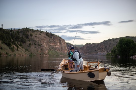 Angler fights a fish from a boat on the Gunnison River.